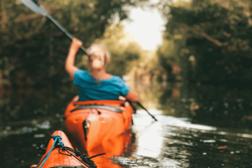 Female in orange kayak on river
