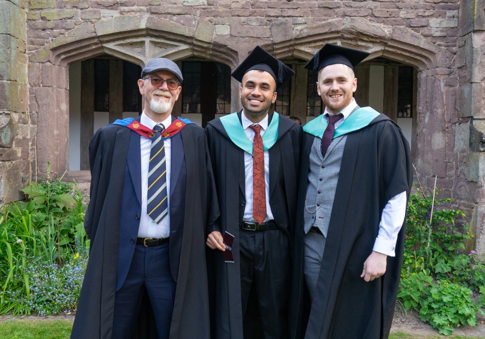 2 students and a lecturer standing side by side 