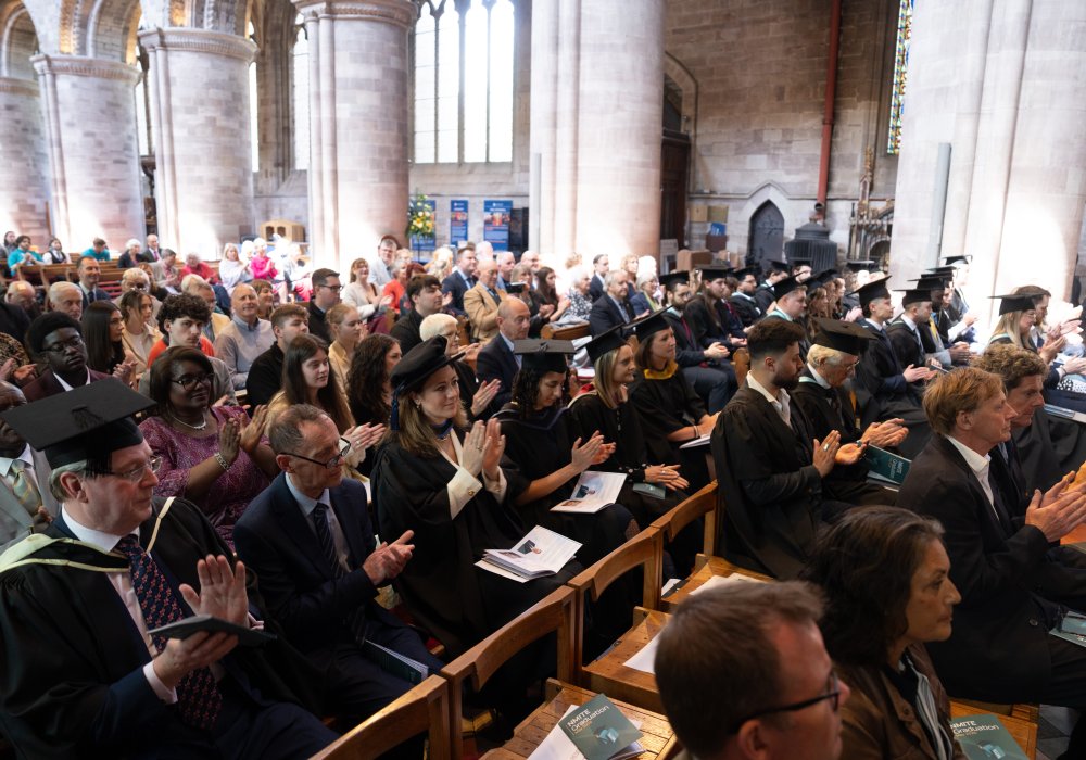 NMITE graduates clapping hands in the hereford cathedral