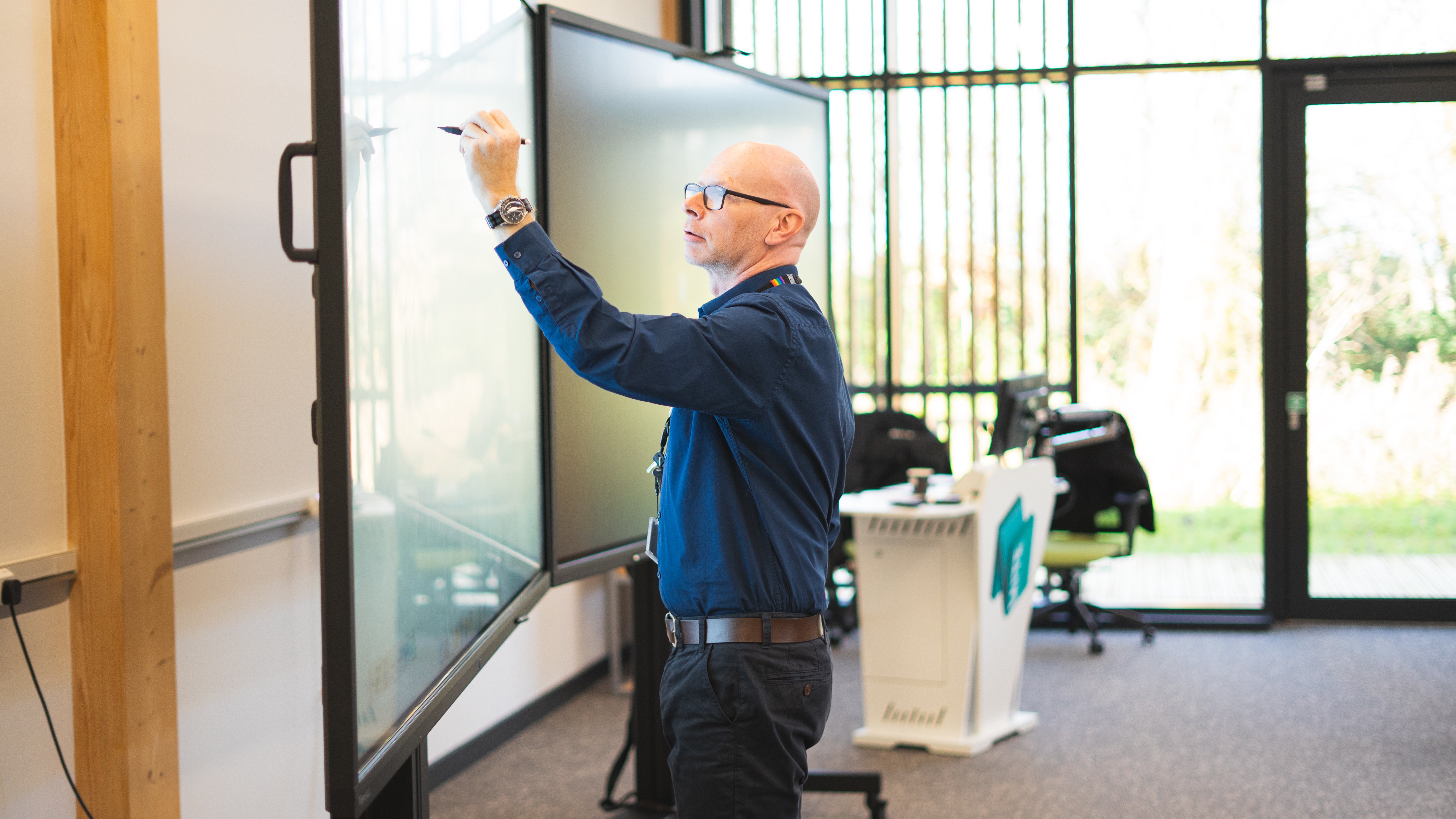Associate Professor Peter Metcalfe delivering training - writing on a digital white board
