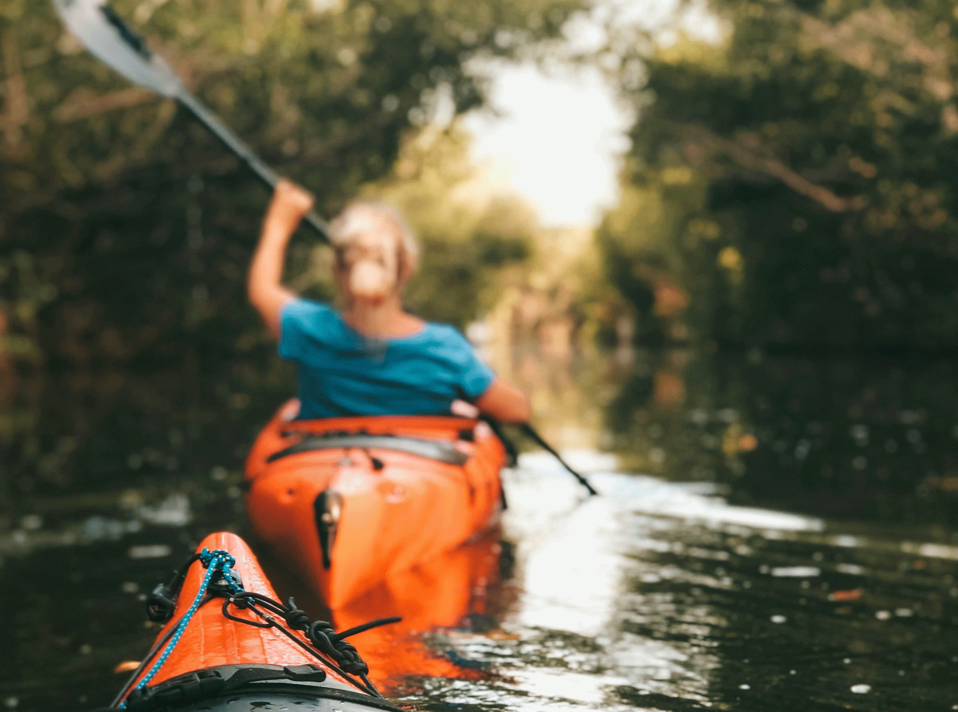 Female in orange kayak on river