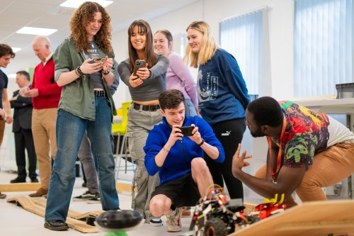 NMITE students grouped together taking a photo in the studio of their mechatronics module outcome