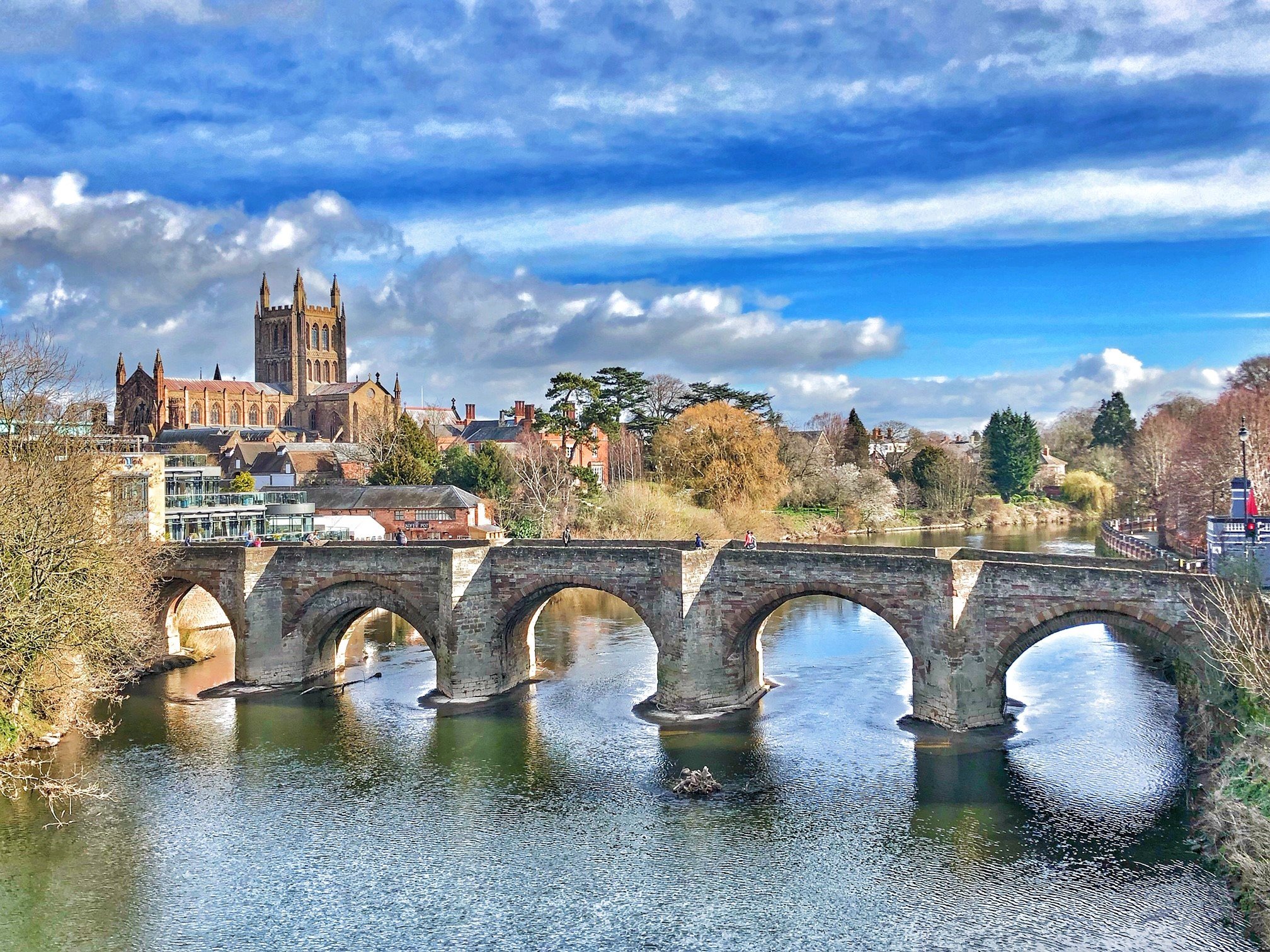 Hereford old bridge over the rive wye, The cathedral is in the background and the sky is a bright shade of blue