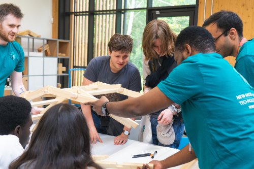 Open day attendees and NMITE students working on a Davinci bridge challenge