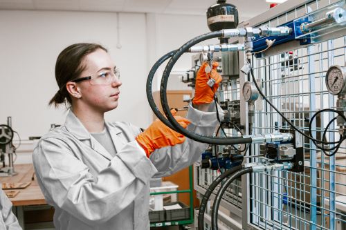 NMITE Student wearing a lab coat operating machinery