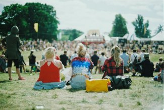 Female young people at festival sitting on grass