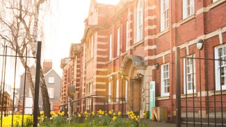 NMITE Blackfriars campus in the sun with daffodils