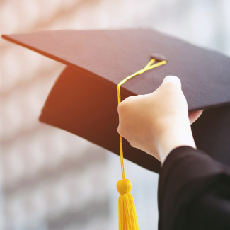 Person holding a graduation cap 