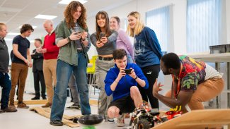 A group of NMITE students taking photos of their mechatronics project