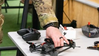 hand on drone on table