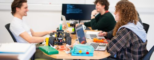 A group of NMITE students working together at a table